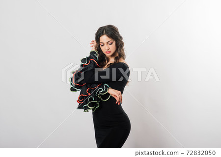 Portrait of beautiful young woman dancing flamenco in studio 72832050