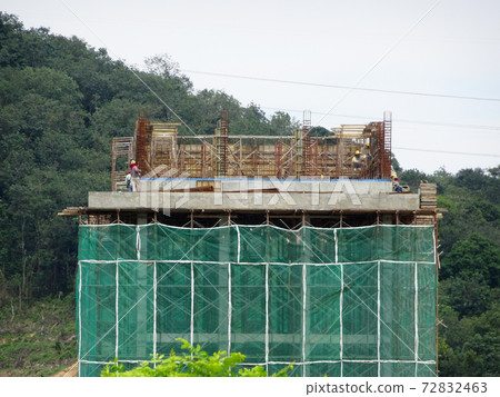 MALACCA, MALAYSIA -MARCH 14, 2020: Construction workers working at height at the construction site. They are supplied with harnesses and other safety equipment to prevent them from having an accident. 72832463