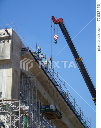 MALACCA, MALAYSIA -MARCH 14, 2020: Construction workers working at height at the construction site. They are supplied with harnesses and other safety equipment to prevent them from having an accident. 72832466
