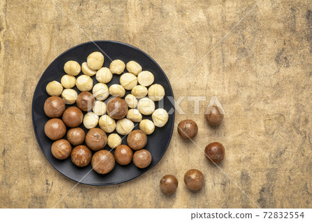 macadamia nuts on a black plate 72832554