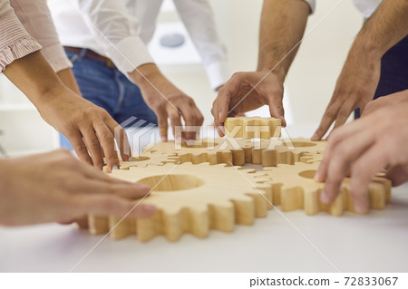 Hands of people office workers business partners making common picture of wooden gears Hands of people office workers business partners making common picture of wooden gears 72833067