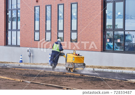 Work to tighten asphalt with a hand guide roller 72833487