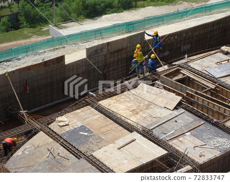 KUALA LUMPUR, MALAYSIA -JULY 16, 2017: Carpenters fabricate timber and plywood formwork at the construction site. Timber formwork as a mold to the reinforced concrete structure. KUALA LUMPUR, MALAYSIA -JULY 16, 2017: Carpenters fabricate timber and plywood formwork at the construction site. Timber formwork as a mold to the reinforced concrete structure. 72833747