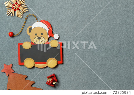 Christmas decorations made of wood and straw on a gray textile background. Horizontally with space Christmas decorations made of wood and straw on a gray textile background. Horizontally with space 72835984