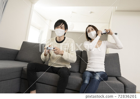 情侶們戴著面具享受最新的電子遊戲/情侶們與戀人享受遊戲/情侶對遊戲機著迷 72836201