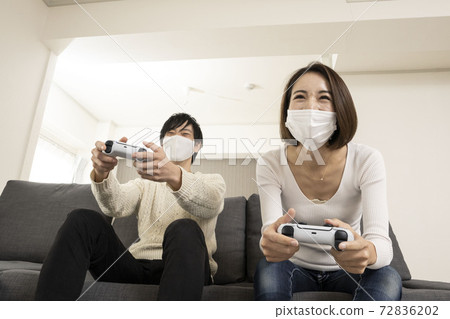 情侶們戴著面具享受最新的電子遊戲/情侶們與戀人享受遊戲/情侶對遊戲機著迷 72836202