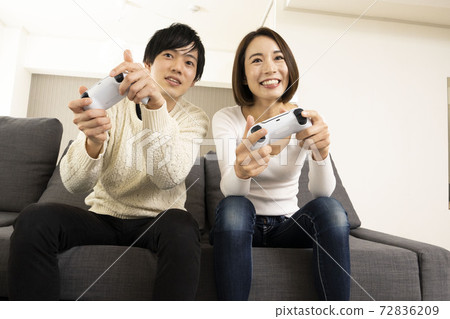 夫妻在客廳裡享受電子遊戲/與戀人一起觀看遊戲/夫妻對遊戲機著迷 72836209