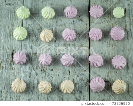 Meringue cakes on wooden background 72836950