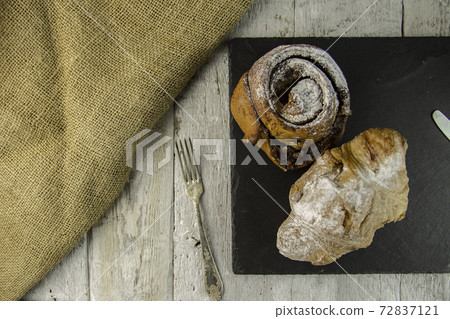sweet buns on a rough wooden background 72837121