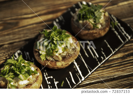 Stuffed mushrooms on a rough wooden surface 72837153