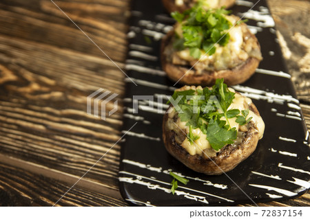 Stuffed mushrooms on a rough wooden surface 72837154