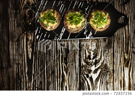 Stuffed mushrooms on a rough wooden surface 72837156