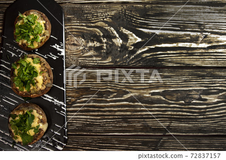 Stuffed mushrooms on a rough wooden surface Stuffed mushrooms on a rough wooden surface 72837157