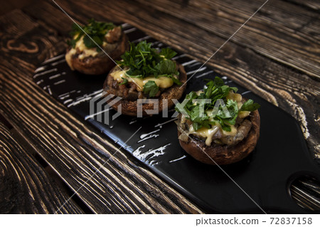 Stuffed mushrooms on a rough wooden surface Stuffed mushrooms on a rough wooden surface 72837158
