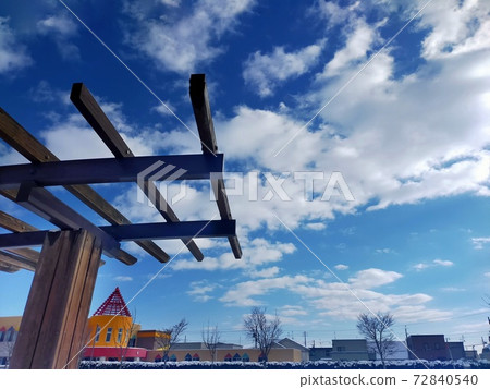 The blue sky extends from between the wooden roofs. 72840540