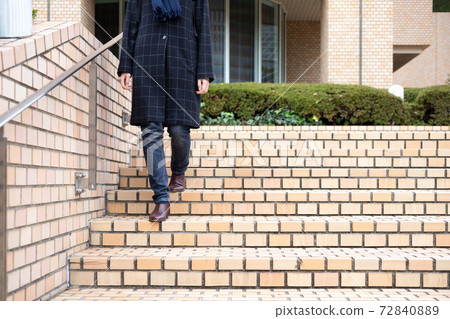 Young woman descending the brick stairs [winter] 72840889