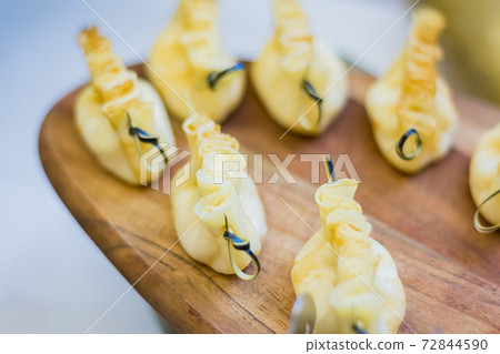 Baked dough with cottage cheese on a skewer. Mini snack on the Board. Baked dough with cottage cheese on a skewer. Mini snack on the Board. 72844590