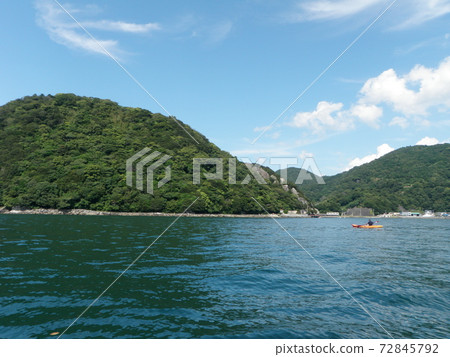 淡島和從摩托艇上方操縱皮划艇的人的遠景 淡島和從摩托艇上方操縱皮划艇的人的遠景 72845792