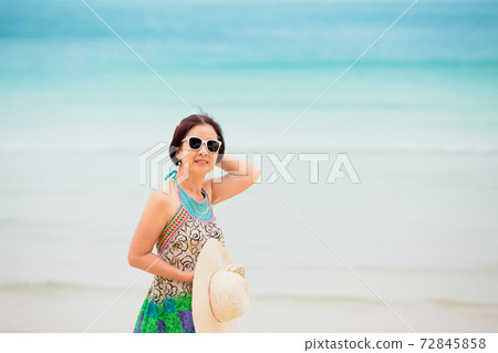 Asian middle aged woman relaxing at chaweng beach in koh samui ,Thailand. 72845858