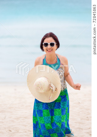 Asian middle aged woman relaxing at chaweng beach in koh samui ,Thailand. 72845863