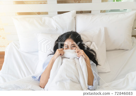 Top view of the beautiful Asian young woman in bed under the blanket. Top view of the beautiful Asian young woman in bed under the blanket. 72846083