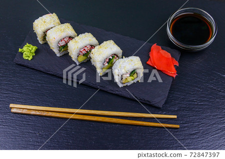 Uramaki sushi rolls with surimi on a black slate Uramaki sushi rolls with surimi on a black slate 72847397