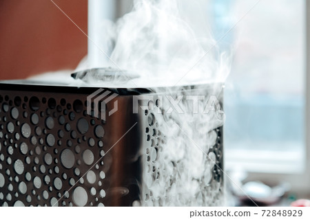 Vapor from humidifier in the morning light. Steam from the air humidifier. Air humidity level in a home. Selective focus 72848929