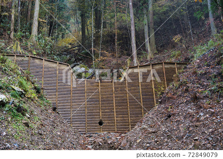 A sabo dam built on the hillside to prevent landslides. Sabo dam using wooden formwork. A sabo dam built on the hillside to prevent landslides. Sabo dam using wooden formwork. 72849079