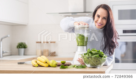 Green blend of smoothie made by a woman on healthy diet at home Green blend of smoothie made by a woman on healthy diet at home 72849366