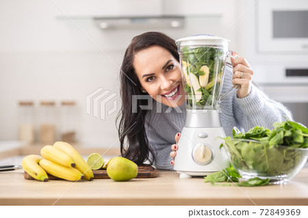 Vitamins packed blender ready to be mixed into a smoothie by a beautiful woman Vitamins packed blender ready to be mixed into a smoothie by a beautiful woman 72849369