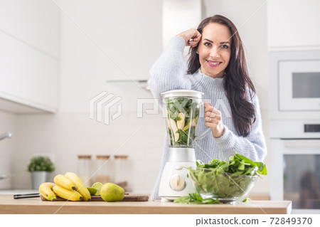 Vitamins packed blender ready to be mixed into a smoothie by a beautiful woman 72849370
