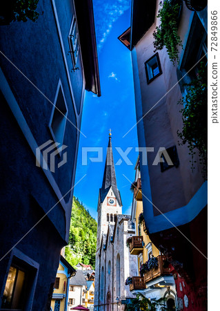 Narrow Alley With Historic Buildings And View to Church In Picturesque Lakeside Town Hallstatt In Austria Narrow Alley With Historic Buildings And View to Church In Picturesque Lakeside Town Hallstatt In Austria 72849866