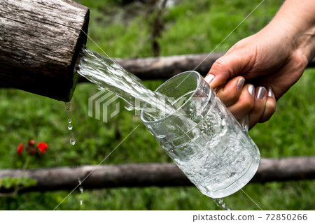Big Glass Filled With Clear Mountain Drinking Water From A Wooden Spring Big Glass Filled With Clear Mountain Drinking Water From A Wooden Spring 72850266