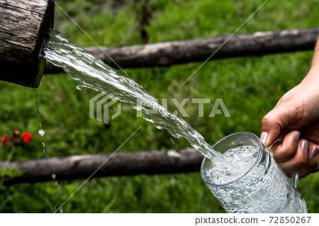 Big Glass Filled With Clear Mountain Drinking Water From A Wooden Spring Big Glass Filled With Clear Mountain Drinking Water From A Wooden Spring 72850267