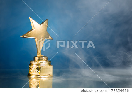 gold star trophy in smoke, blue background 72854616