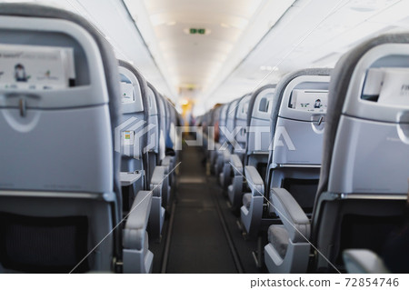 airline passenger seats and aisle in airplane cabin 72854746