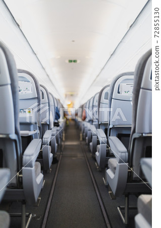 airline passenger seats and aisle in airplane cabin 72855130