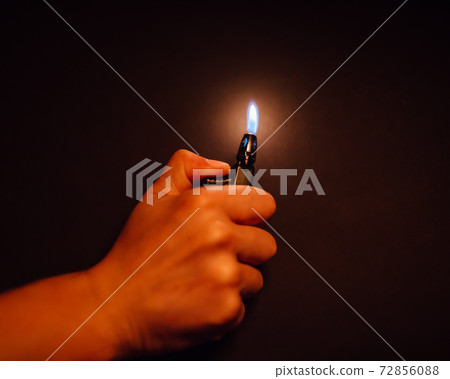 cigarette lighter igniting by a hand 72856088