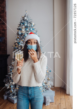 African american woman in protective mask with glass of champagne African american woman in protective mask with glass of champagne 72857126