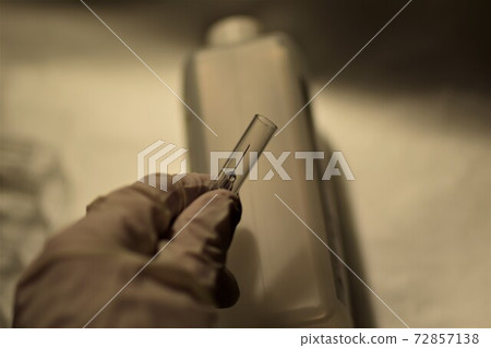close up of a hand holding an injection 72857138
