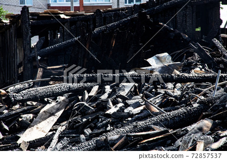 Logs from a burnt house, place after a fire 72857537