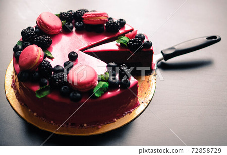 Delicious cake with fresh strawberries, raspberries, blueberry, currants. cut piece of cake and blade on wooden background. 72858729