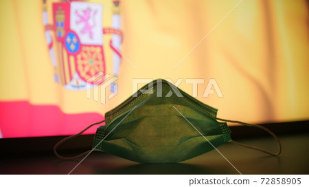 Medical mask against blurred flag of Spain. COVID-19 outbreak concept Medical mask against blurred flag of Spain. COVID-19 outbreak concept 72858905