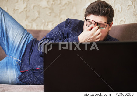 Concept, a Caucasian man wearing glasses hurts his eyes behind a note beech, copies of space 72860296