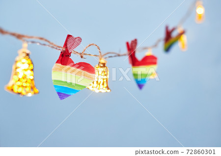 Lgbt valentine's day concept, rainbow heart on garland on blue background, copy space Lgbt valentine's day concept, rainbow heart on garland on blue background, copy space 72860301