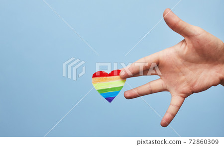 Lgbt valentine's day concept, rainbow heart in hand on blue background, copy space Lgbt valentine's day concept, rainbow heart in hand on blue background, copy space 72860309
