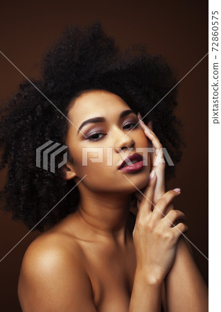 pretty young african american woman with curly hair posing cheerful gesturing on brown background, lifestyle people concept pretty young african american woman with curly hair posing cheerful gesturing on brown background, lifestyle people concept 72860575