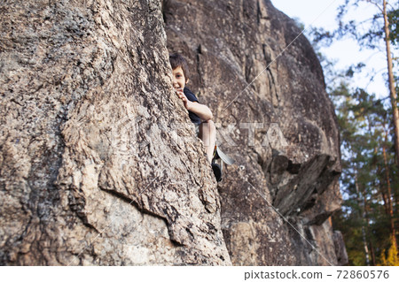 cute teen kid climbing on rock with insurance, lifestyle sport people concept cute teen kid climbing on rock with insurance, lifestyle sport people concept 72860576