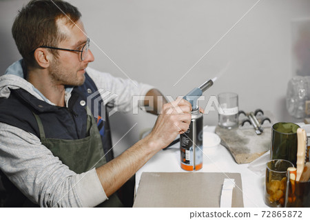 A man processes a bottle into a glass 72865872
