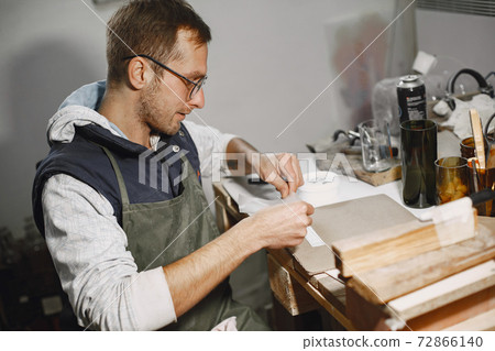 A man sticks stickers on glasses 72866140